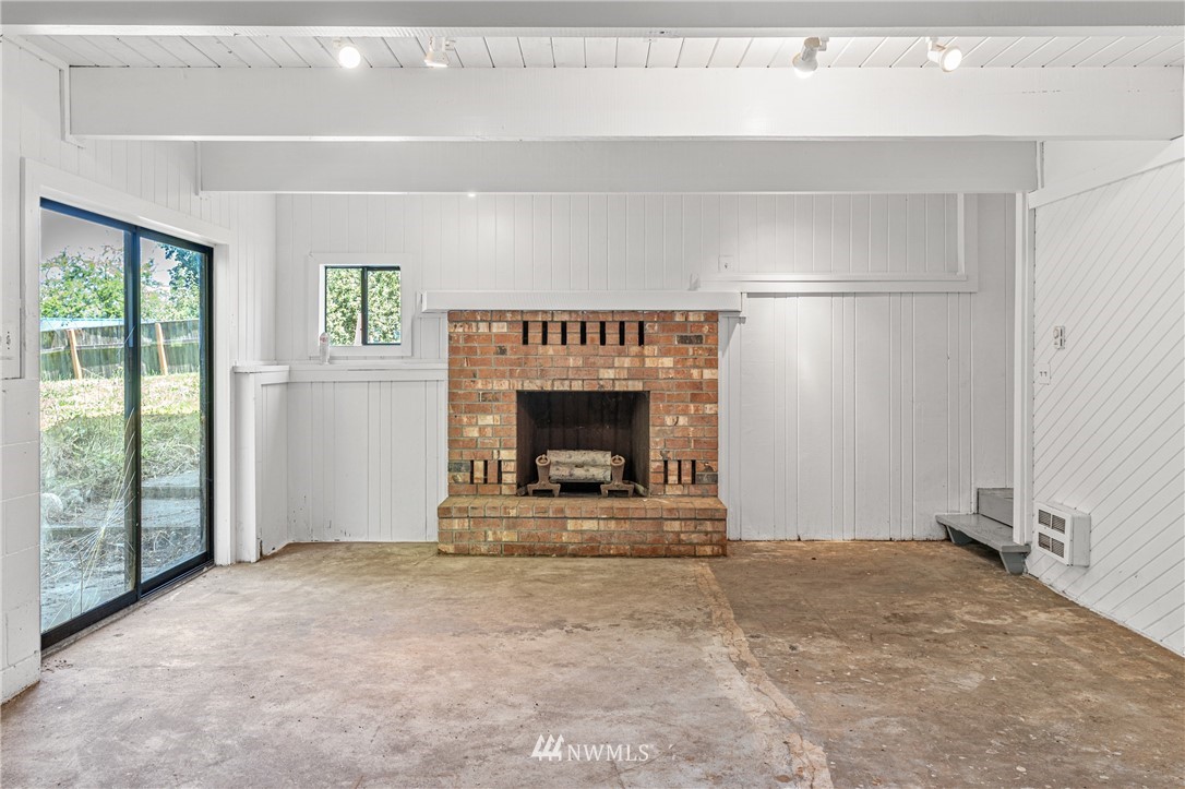 929 Blackburn Road Camano Island, WA 98282 - Photo 32 of 39 a view of an empty room with a fireplace and a window