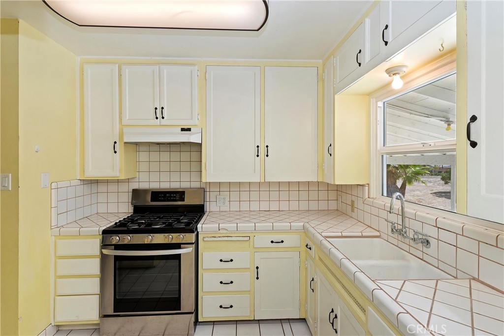 20407 Markham Street Perris, CA 92570 - Photo 8 of 26 a kitchen with granite countertop a sink stove and cabinets
