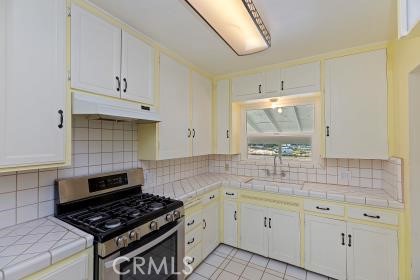 20407 Markham Street Perris, CA 92570 - Photo 9 of 26 a kitchen with granite countertop a stove sink and cabinets