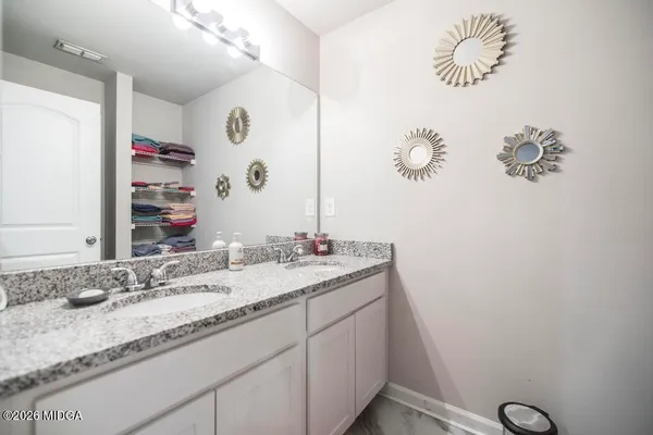 a bathroom with a granite countertop sink a mirror and vanity