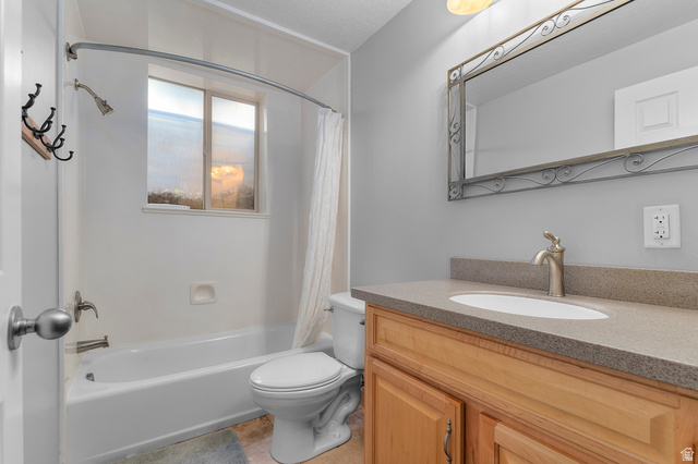1501 West Elk Circle Mapleton, UT 84664 - Photo 35 of 39 Bathroom featuring a wood-finish vanity with a built-in sink, a neutral-toned countertop, and an ornate framed mirror