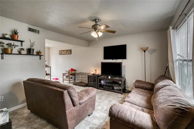 a living room with furniture a flat screen tv and a fireplace