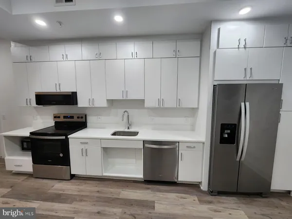 a kitchen with stainless steel appliances a refrigerator sink and cabinets
