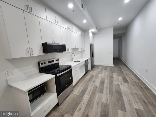 a large kitchen with a stove and a sink
