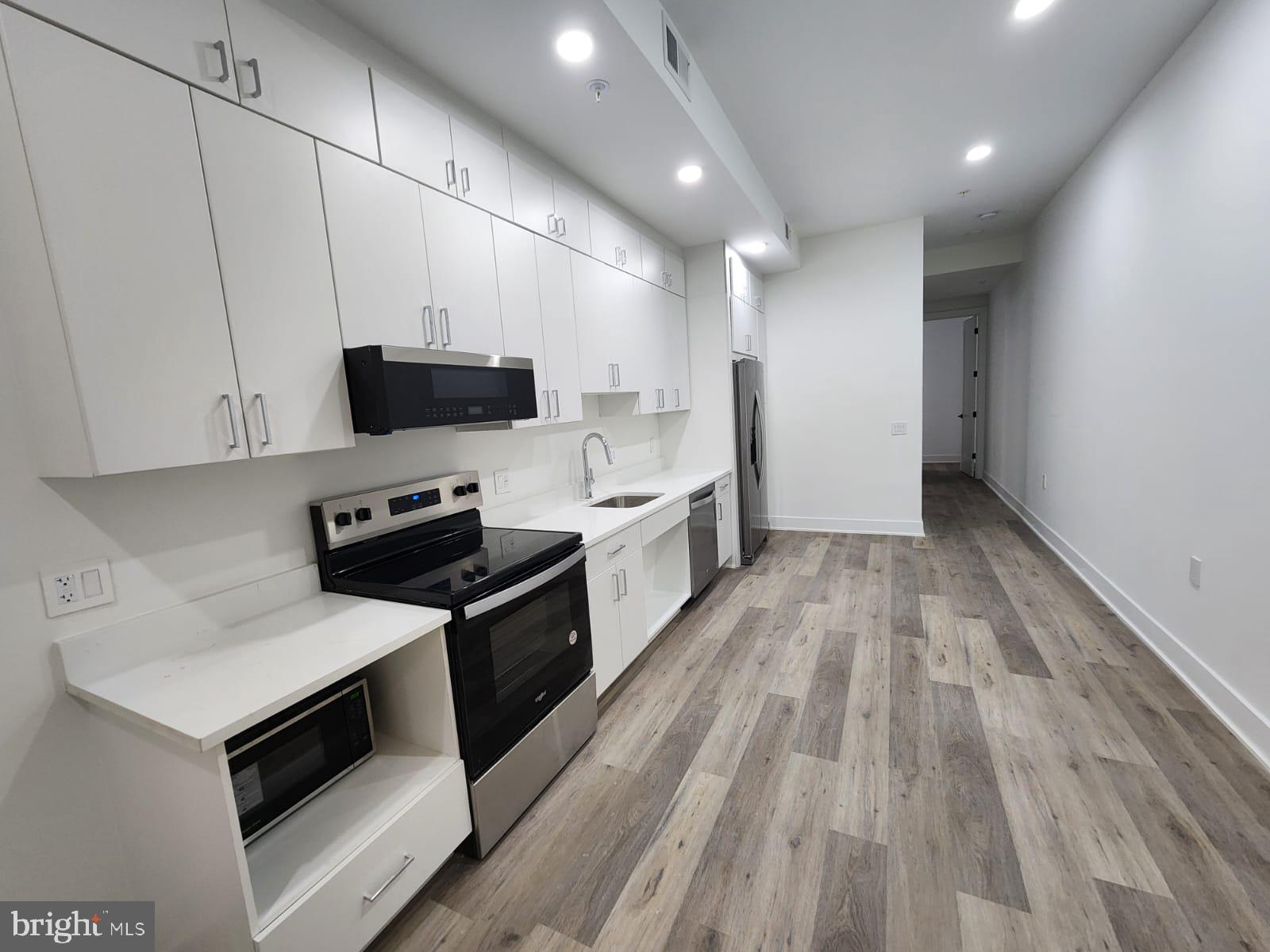 4905 Georgia Avenue Northwest, Unit 105 Washington, DC 20011 - Photo 3 of 18 a large kitchen with a stove and a sink