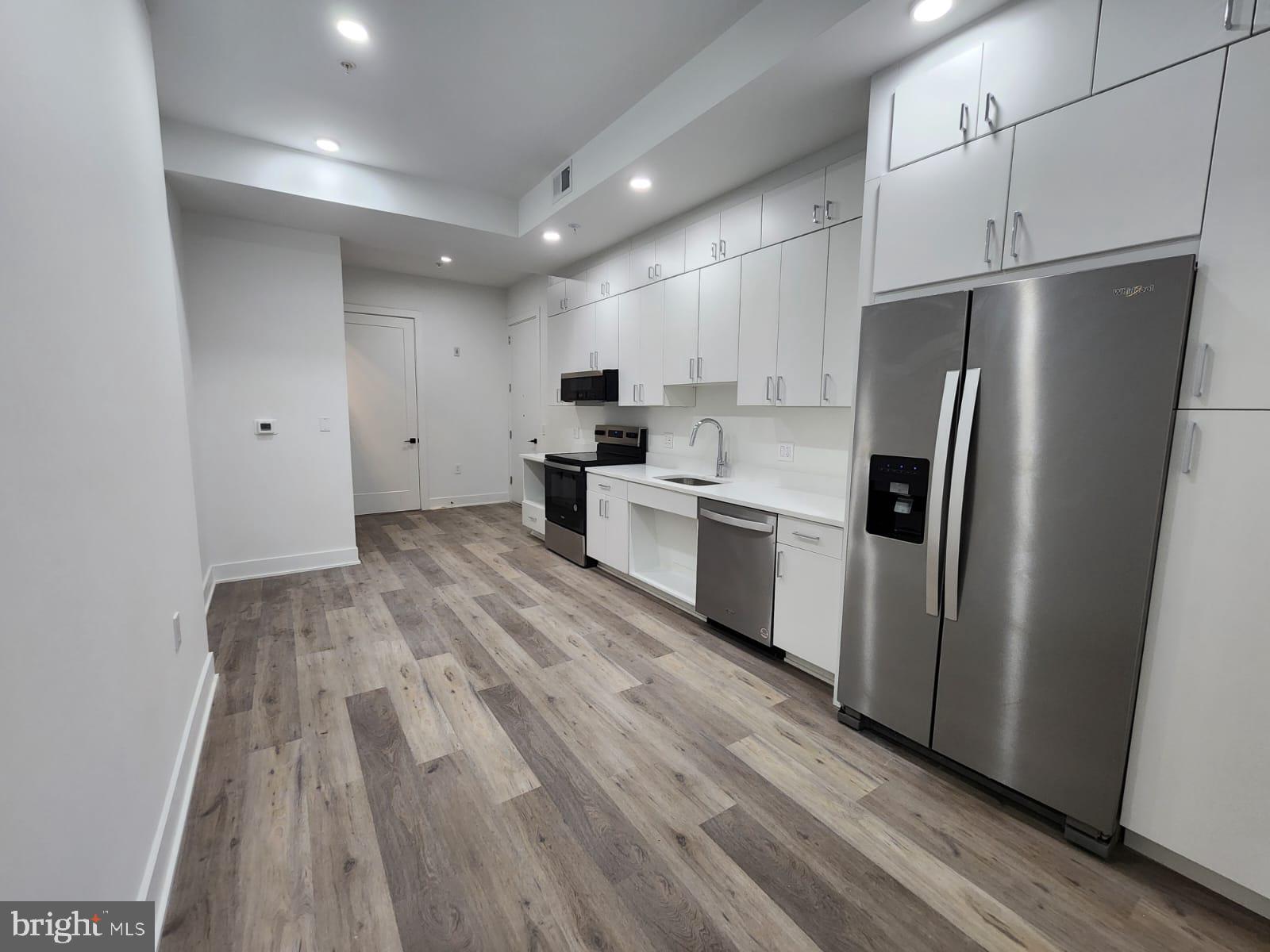 4905 Georgia Avenue Northwest, Unit 105 Washington, DC 20011 - Photo 4 of 18 a kitchen with stainless steel appliances a refrigerator sink and cabinets
