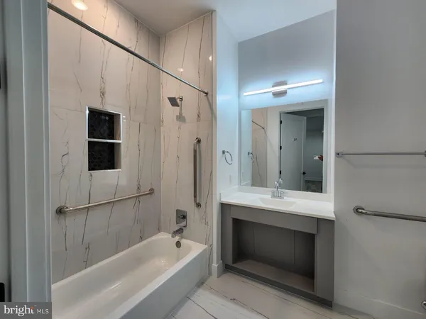 a bathroom with a tub a sink and a mirror