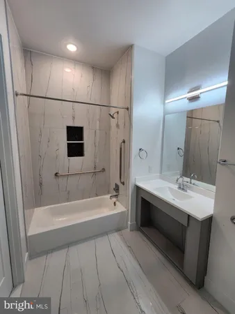 a spacious bathroom with a tub a sink a mirror and a shower