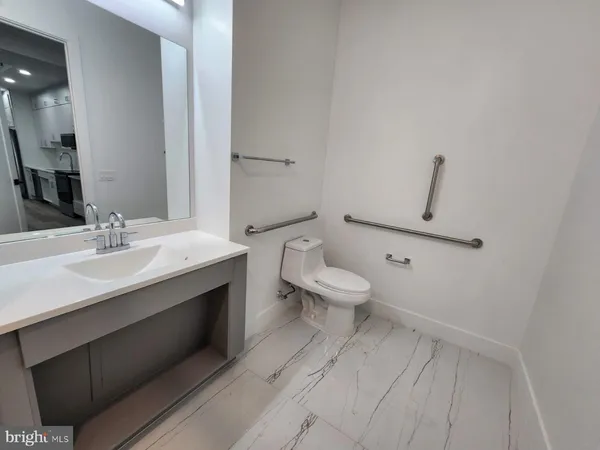 a bathroom with a sink mirror and toilet