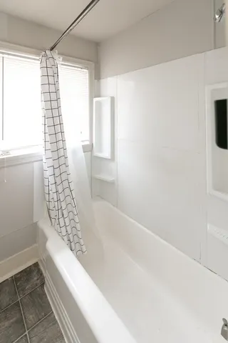 a bathroom with a bathtub and shower