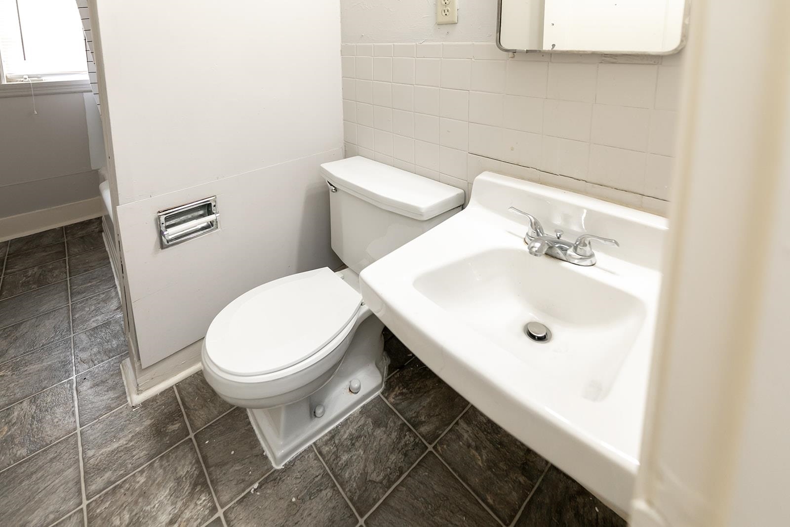 1515 Madison Avenue Memphis, TN 38104 - Photo 15 of 19 a white toilet sitting next to a bathroom sink