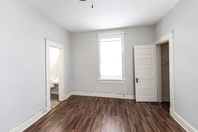 an empty room with wooden floor and window