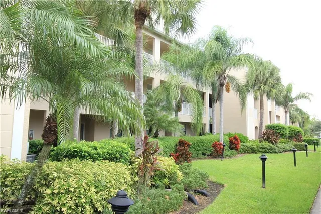a front view of multi story residential apartment building with yard and green space