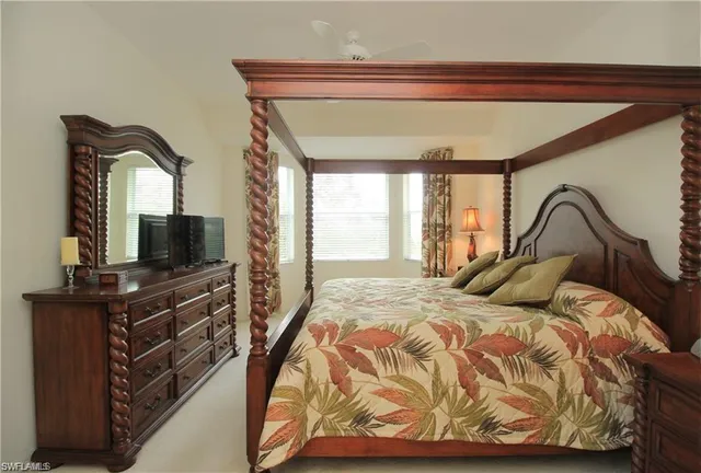 a bedroom with a bed and a flat tv screen on the dresser