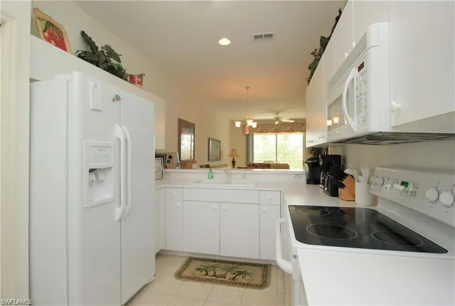 a kitchen with white cabinets and refrigerator