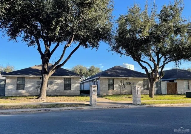 a view of a house with a large space next to a large tree