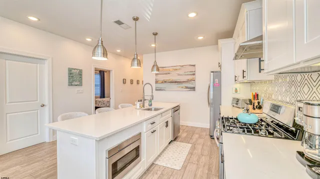 a kitchen with a sink a stove a refrigerator and a oven