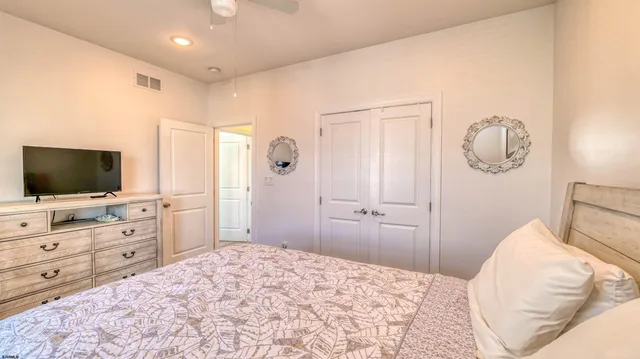 a bedroom with a bed and a flat screen tv in white cabinets