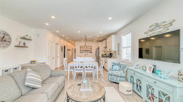 a living room with furniture kitchen view and a flat screen tv