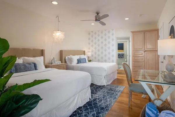 a spacious bedroom with two beds and a chandelier