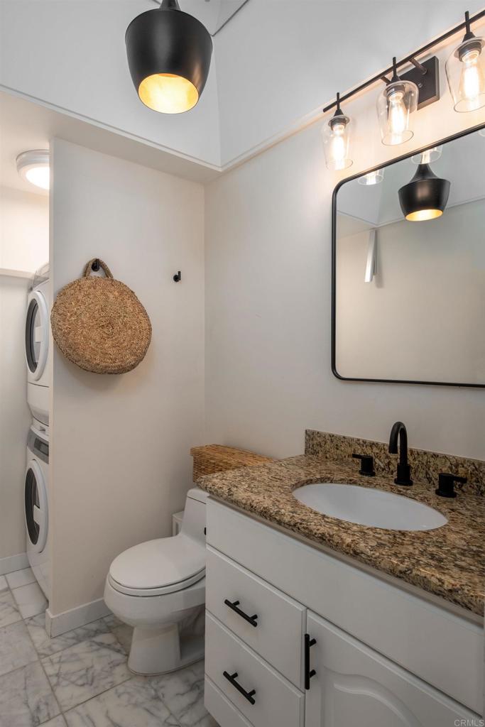 2005 Costa Del Mar Road, Unit 627 Carlsbad, CA 92009 - Photo 18 of 21 a bathroom with a granite countertop toilet sink and mirror