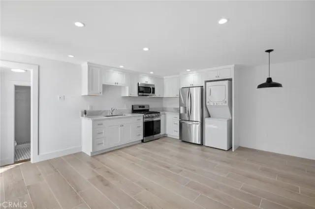 a kitchen with refrigerator a microwave and white cabinets