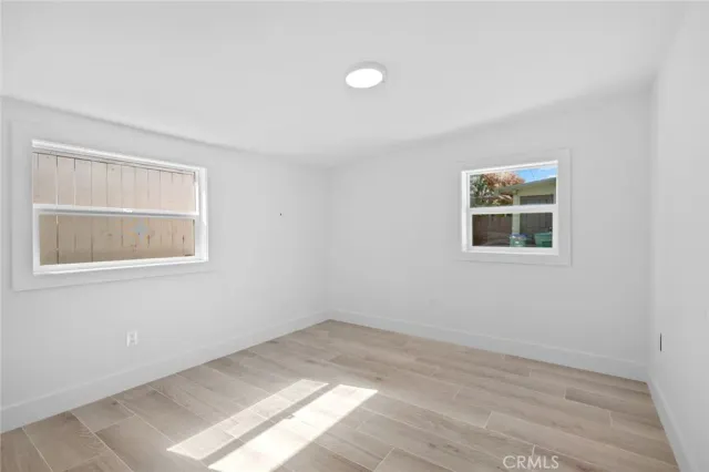 a view of a room that has a window and wooden floor