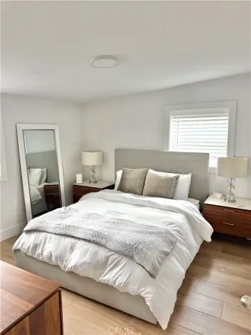 a bedroom with a bed and wooden floor