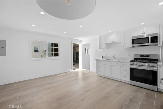 a large kitchen with stainless steel appliances granite countertop a stove and a sink