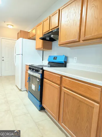 a kitchen with a refrigerator sink and cabinets