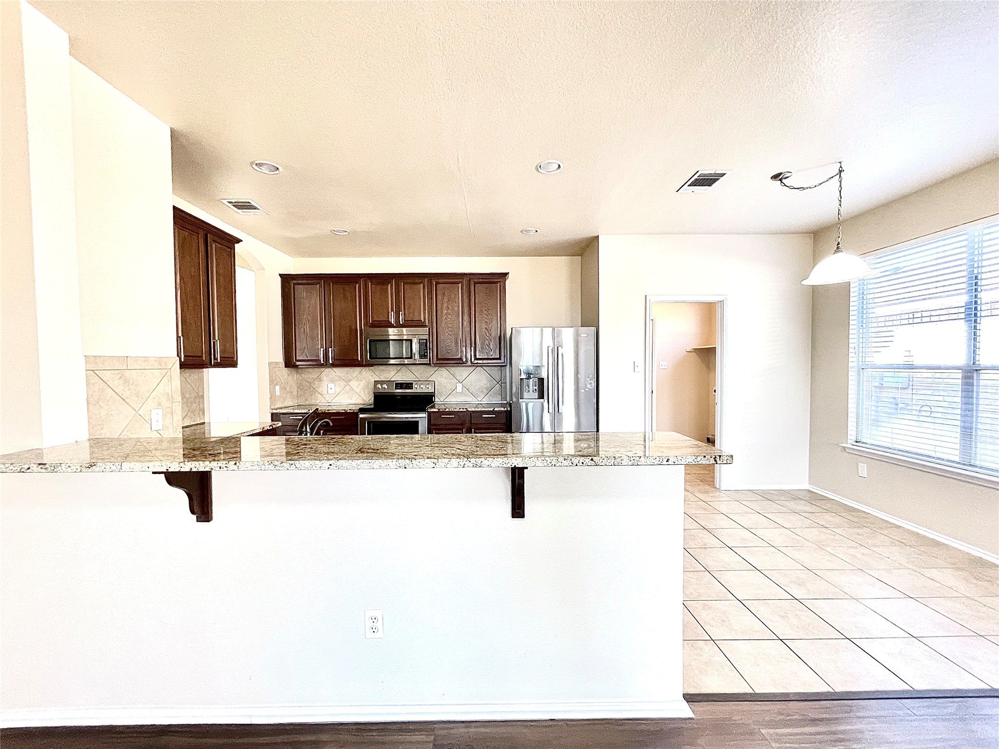 508 Emma Rose Trail Leander, TX 78641 - Photo 5 of 40 A well-equipped kitchen features rich cabinetry, granite countertops, and stainless steel appliances.
