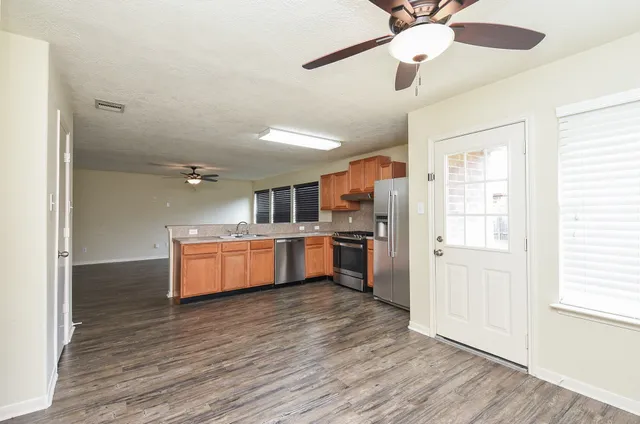 a kitchen with stainless steel appliances kitchen island wooden floors and granite counter tops