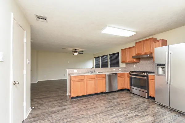 a kitchen with stainless steel appliances granite countertop a refrigerator and a stove top oven