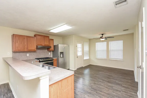 a kitchen that has a sink a stove and wooden floor