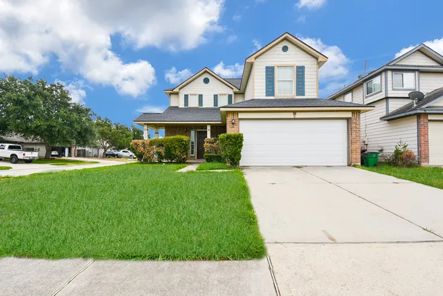 a front view of a house with a yard and trees