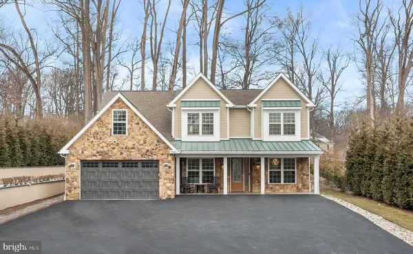 a front view of a house with a garden and trees