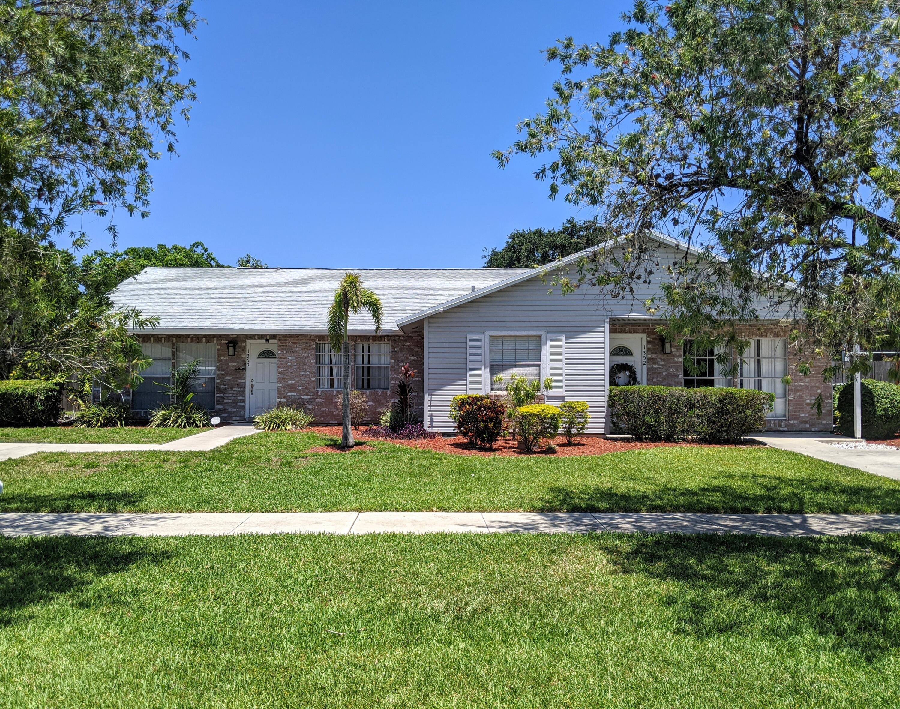 a view of a house with a yard and sitting area