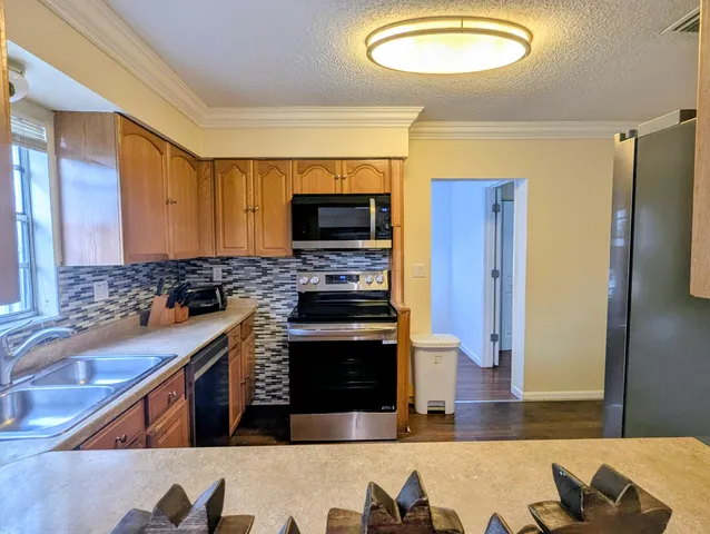 a kitchen with stainless steel appliances granite countertop a stove refrigerator and microwave