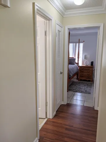 a view of a hallway with wooden floor and closet