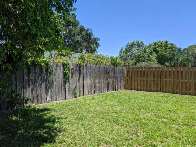 a view of wooden fence with trees in the background