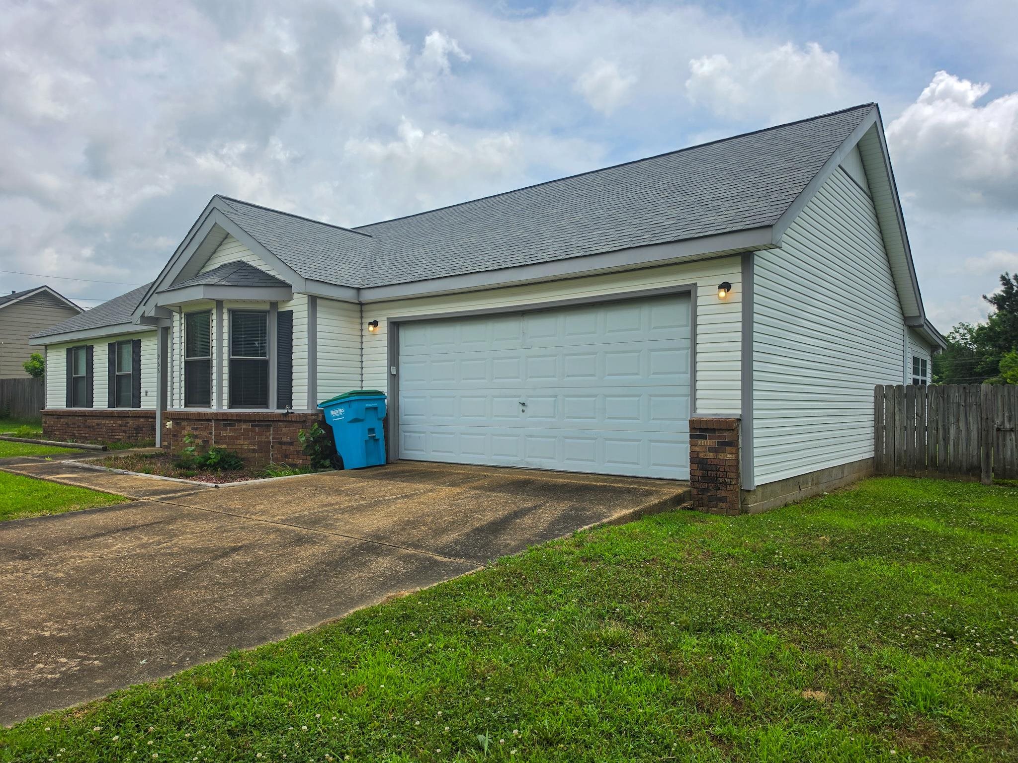 966 Beaver Road Munford, TN 38058 - Photo 3 of 32 Exterior featuring light-colored siding with dark trim, a two-car garage, a bay window with shutters, and a partial brick facade