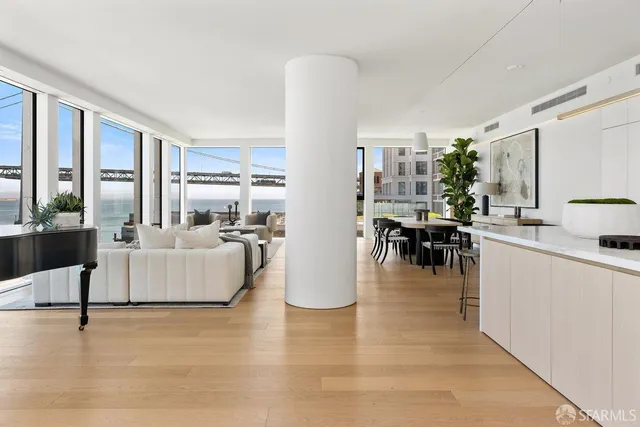 a living room with furniture floor to ceiling window and a table