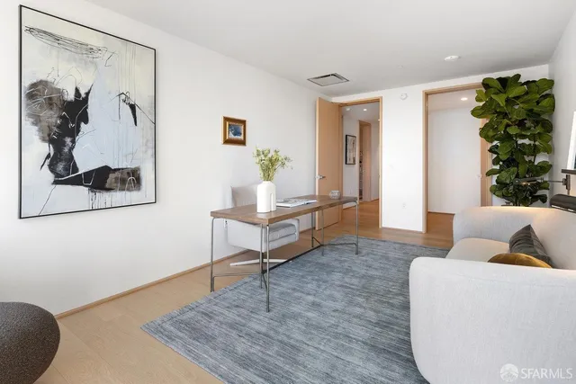 a balcony with couple of chairs and a potted plant