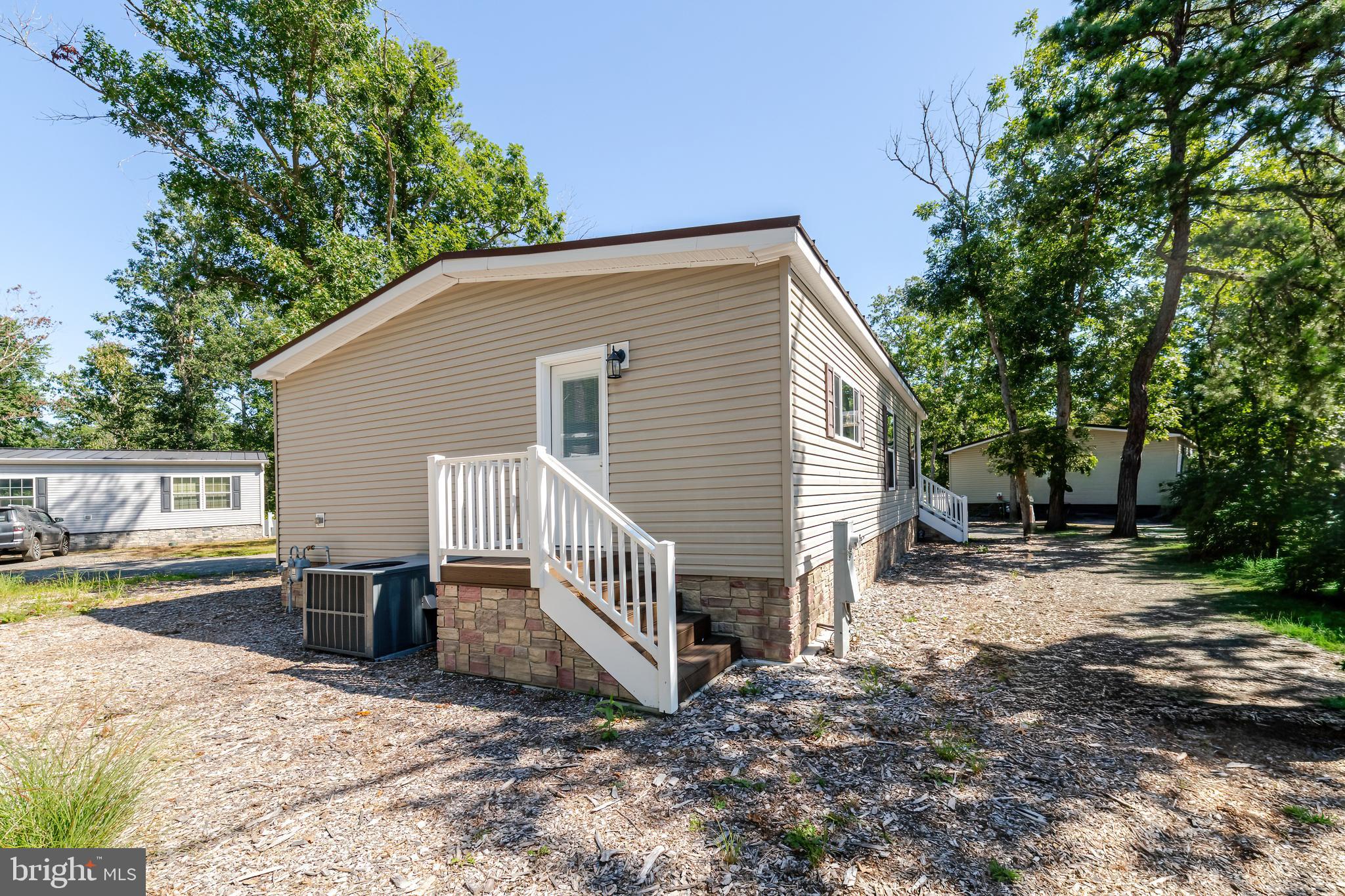 106 East Moss Mill Road, Unit T38 Galloway Township, NJ 08205 - Photo 23 of 28 a view of a small house with yard and trees in the background
