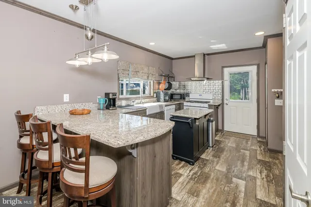 a kitchen with a stove a table and chairs in it