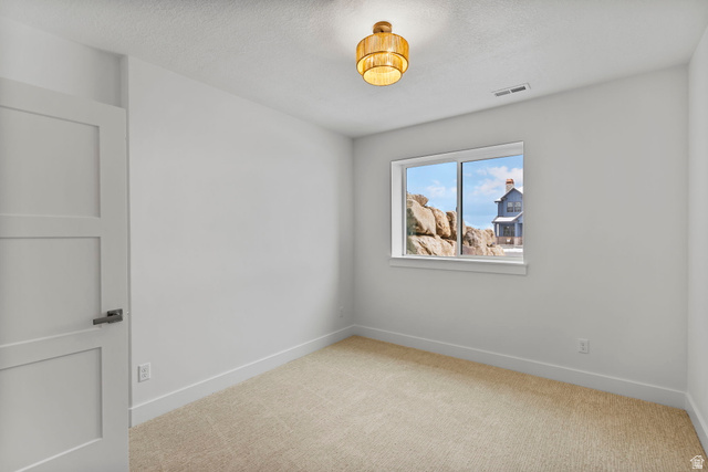 728 East Mountain Road North Ogden, UT 84414 - Photo 13 of 28 Neutral interior room featuring a light-colored carpet, white walls, and a contemporary light fixture