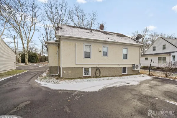 a view of a house with a large tree and wooden fence