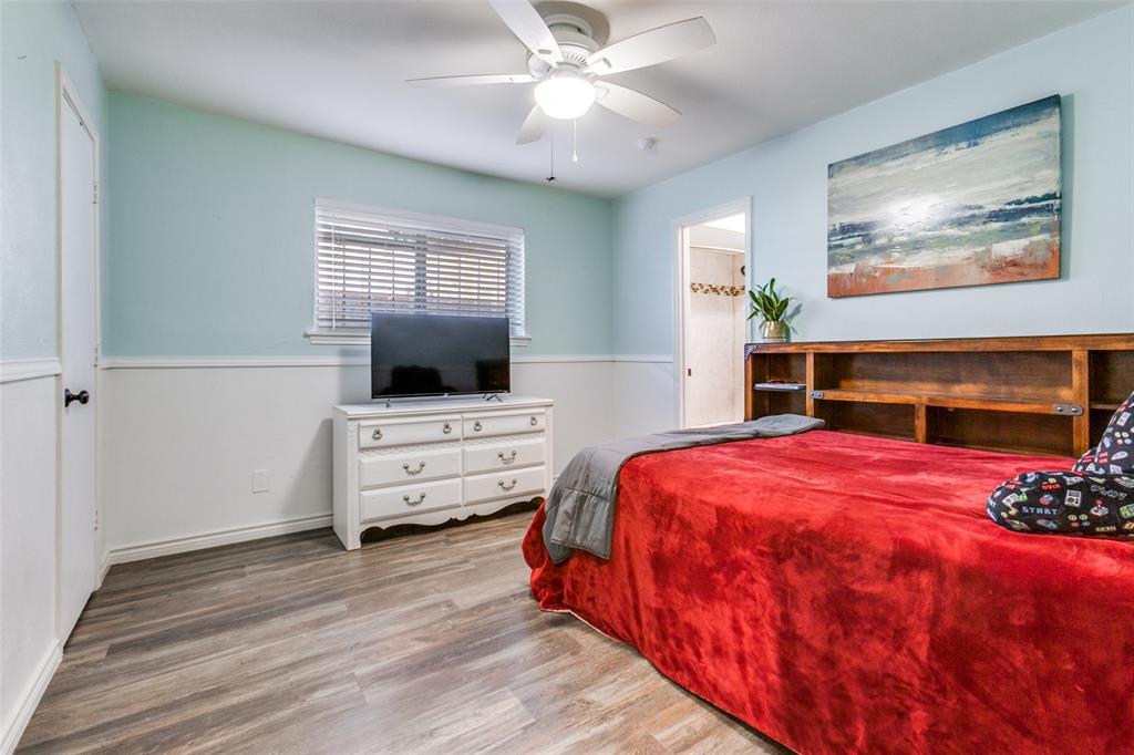 15881 Nedra Way Dallas, TX 75248 - Photo 19 of 26 a bedroom with a bed and a flat screen tv