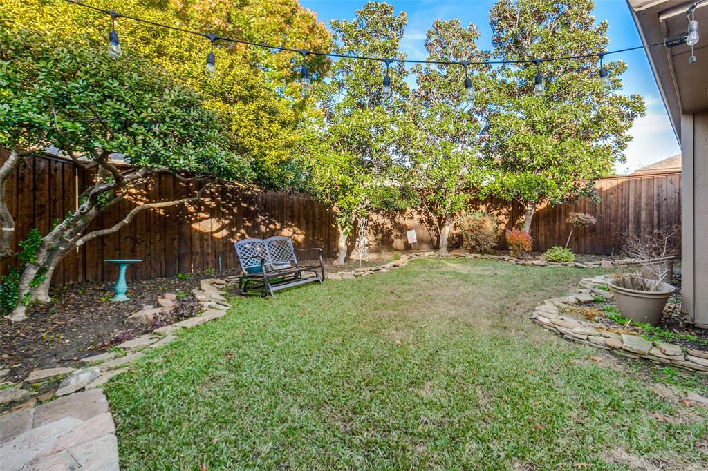 15881 Nedra Way Dallas, TX 75248 - Photo 24 of 26 a view of a backyard with plants and a large tree