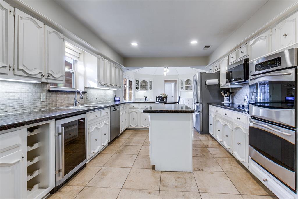 15881 Nedra Way Dallas, TX 75248 - Photo 6 of 26 a kitchen with stainless steel appliances granite countertop a sink a stove top oven a counter space and cabinets